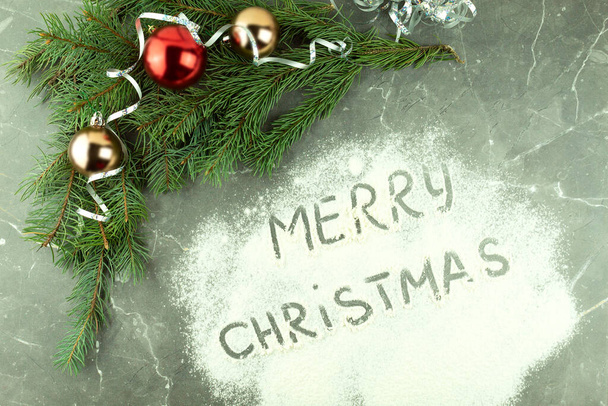 Fondo navideño con texto Feliz Navidad sobre fondo blanco. Texto sobre harina espolvoreada - Foto, imagen