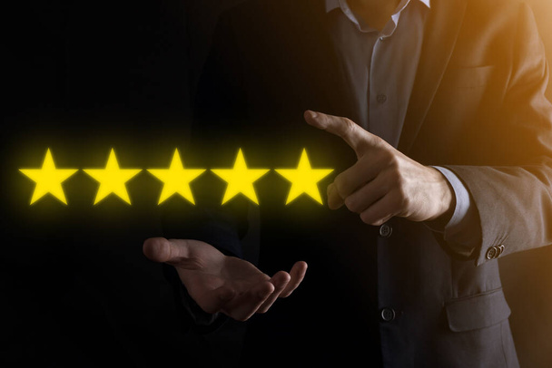 Man hand showing on five star excellent rating.pointing five star symbol to increase rating of company.Review, increase rating or ranking, evaluation and classification concept. - Photo, Image
