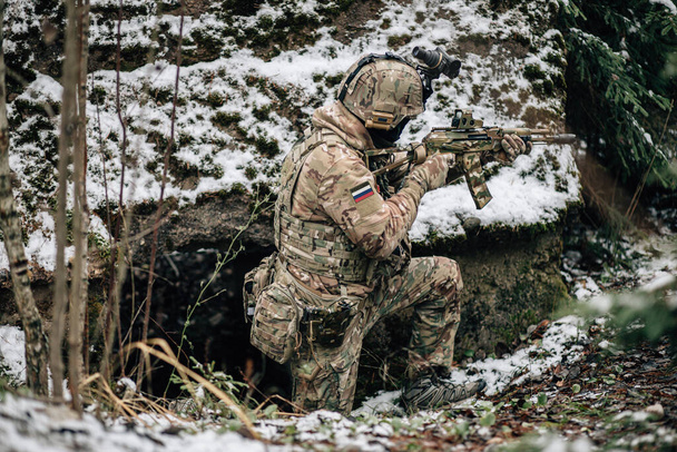 Rus Spetsnaz askeri Kalaşnikov taktik saldırı tüfeğiyle Dağıstan kış dağlarında kamuflaj üniforması giyiyordu. Koldaki metin: Rusya. - Fotoğraf, Görsel