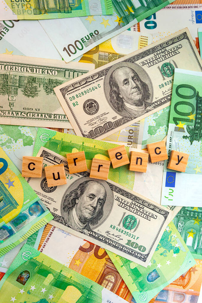 ドルやユーロの紙幣の質感に木製のキューブに通貨の碑文 - 写真・画像