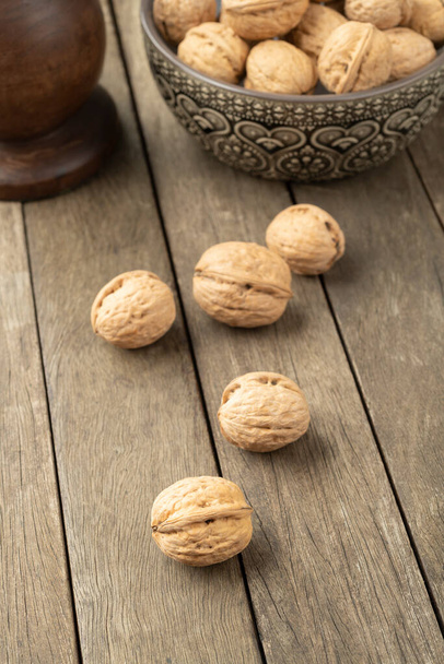 Walnuts over a wooden table and into a bowl. - Foto, immagini