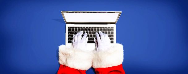 Santa Claus using a laptop computer - Фото, зображення