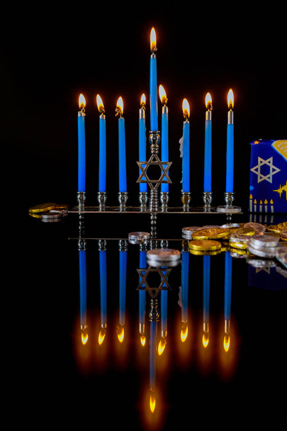Azul velas encendidas en la menorá con monedas de chocolate para Hanukkah fiesta judía. - Foto, Imagen