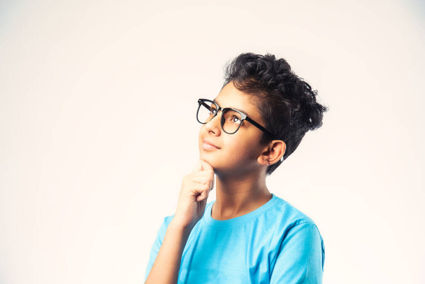 Індійський хлопчина думає про біле походження, азіатський хлопчик носить окуляри і знаходить рішення для чогось - Фото, зображення