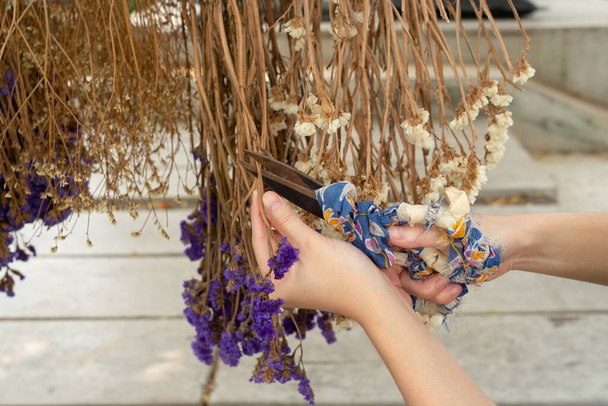 primo piano mano della donna con le forbici per tagliare fiori secchi per decorare opere d'arte - Foto, immagini