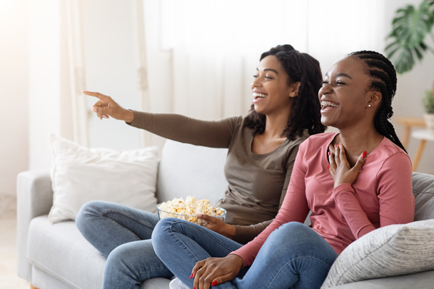 Duas namoradas negras se divertindo em casa, assistindo comédia - Foto, Imagem