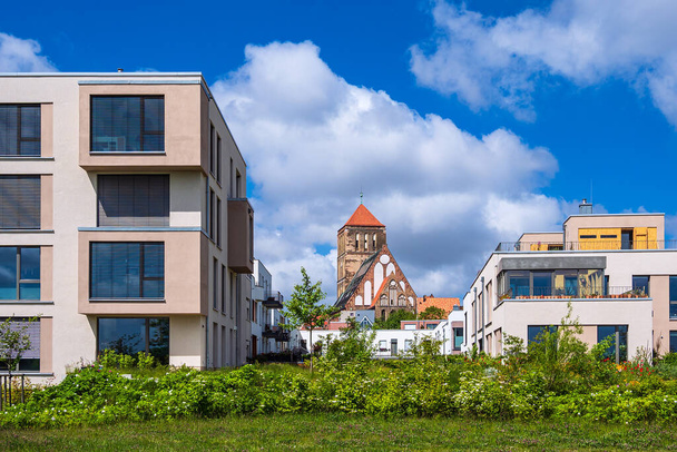Nykyaikaiset rakennukset ja vanha kirkko kaupungissa Rostock, Saksa. - Valokuva, kuva