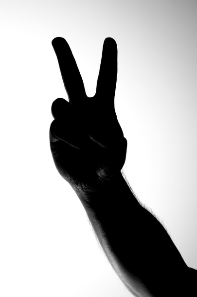 Schwarz-Weiß-Bild einer Handsilhouette, die eine Siegesgeste zeigt - Foto, Bild