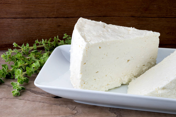 Geleneksel feta peyniri ahşap fıçılara dönüşüyor ve üçgen şeklinde kesiliyor.. - Fotoğraf, Görsel