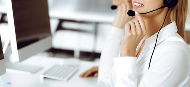 Unknown female customer service representative is consulting clients online using headset.close-up. Call center and business concept - Foto, imagen