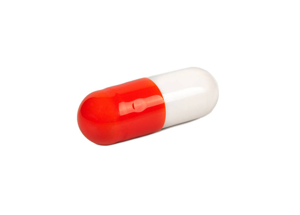 Rode en witte capsule geïsoleerd op een witte achtergrond - Foto, afbeelding