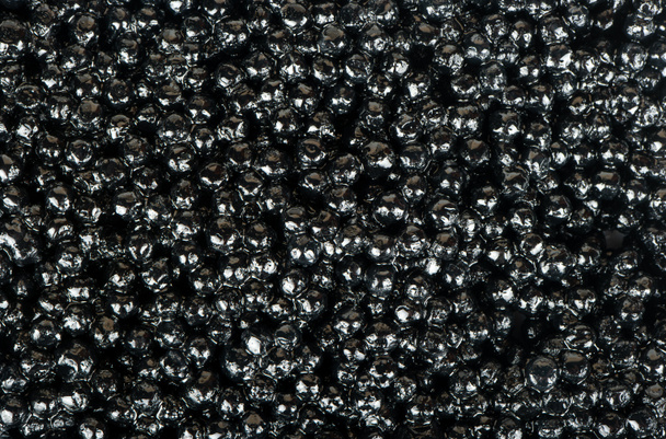 Achtergrond van verse zwarte kaviaar close-up - Foto, afbeelding