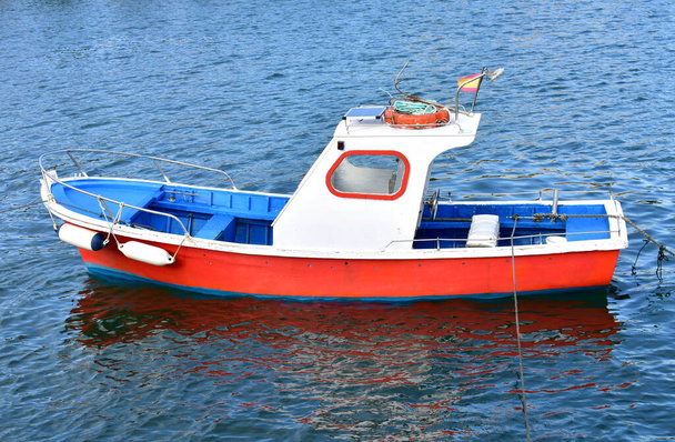 bateau de pêche galicien traditionnel en bois rouge blanc et bleu amarré dans un port. galice, espagne. - Photo, image