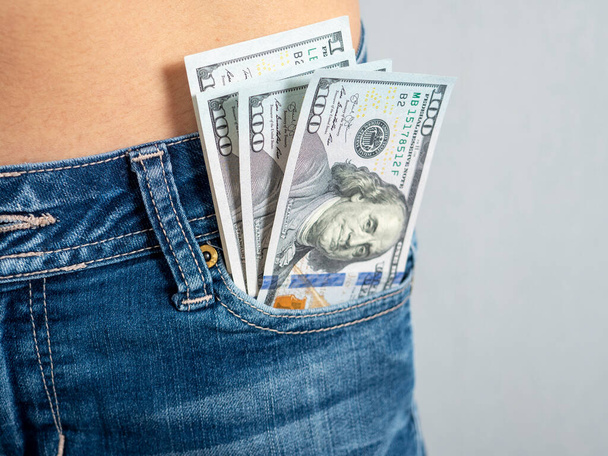 100 bills stick out of the front pocket of his jeans The concept of money in your pocket - Fotoğraf, Görsel