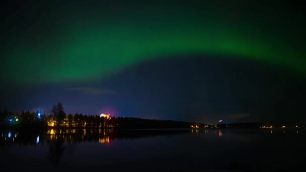 Тайм-ап 4k HD северного света, танцующего над полузамёрзшим озером и городским пейзажем с отражением от воды звезды, полной неба  - Кадры, видео