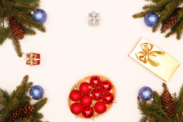 Kerst en Nieuwjaar achtergrond. Fir takken met kegels liggen op een houten achtergrond versierd met kerstkoekjes en kerstballen. - Foto, afbeelding