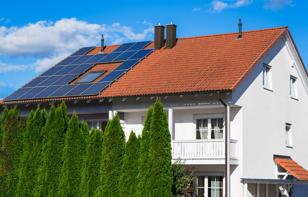 Generikus modern ház (képszerkesztéssel módosítva) fotovoltaikus napelemekkel a tetőn az alternatív energiatermeléshez - Fotó, kép