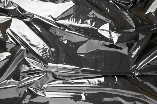 Emballage plastique. Modèle de sac de film brillant noir. Texture cellophane foncé transparente. Fond froissé créatif - Photo, image