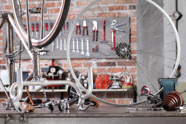 vintage ποδήλατο σε γκαράζ εργαστήριο στον πάγκο εργασίας με εργαλεία, diy και επισκευή έννοια - Φωτογραφία, εικόνα