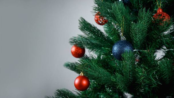 Decorated Christmas tree. Blue and red balloons, Christmas toys. - 写真・画像