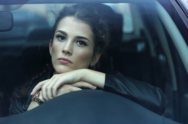Portrait of a beautiful girl behind the windshield of a car  - Fotoğraf, Görsel