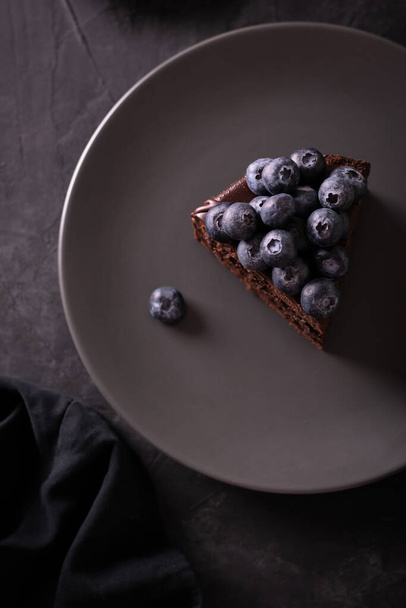 Chocolate cake with berries in a low key flatlay - Foto, imagen