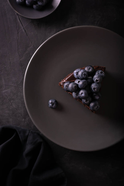 Chocolate cake with berries in a low key flatlay - Φωτογραφία, εικόνα