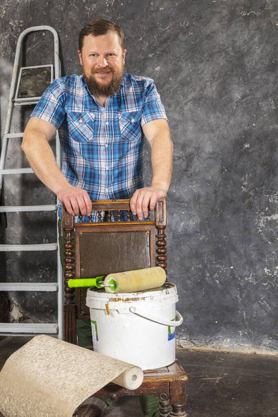 Joyful bearded foreman in green pants with working tools - Photo, Image