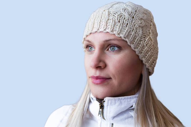 Portrait of a blonde woman with a winter hat isolated on blue background - Foto, immagini