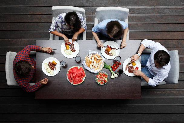Négy barát vacsorázik, felülnézetből - Fotó, kép