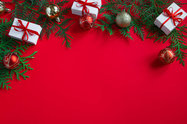 Κουτιά δώρων και γιορτινή διακόσμηση. Χριστουγεννιάτικη σύνθεση σε κόκκινο φόντο. Θέση για κείμενο. - Φωτογραφία, εικόνα
