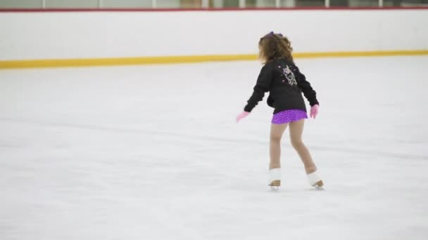 Ragazzina che pratica pattinaggio artistico su pista di pattinaggio su ghiaccio coperta. - Filmati, video