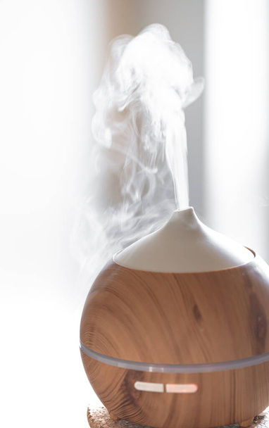 Diffuseur d'huile d'arôme lampe sur une table. Concept d'aromathérapie et de soins de santé. - Photo, image