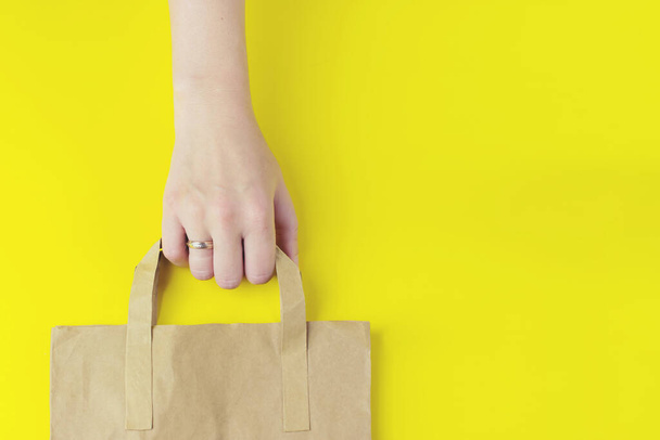 Καφέ σαφές κενό χάρτινη τσάντα χειροτεχνίας για takeaway στο κίτρινο φόντο. Διακόσμηση προτύπων συσκευασίας. Η έννοια της υπηρεσίας παράδοσης. Αντιγραφή χώρου διαφήμισης - Φωτογραφία, εικόνα