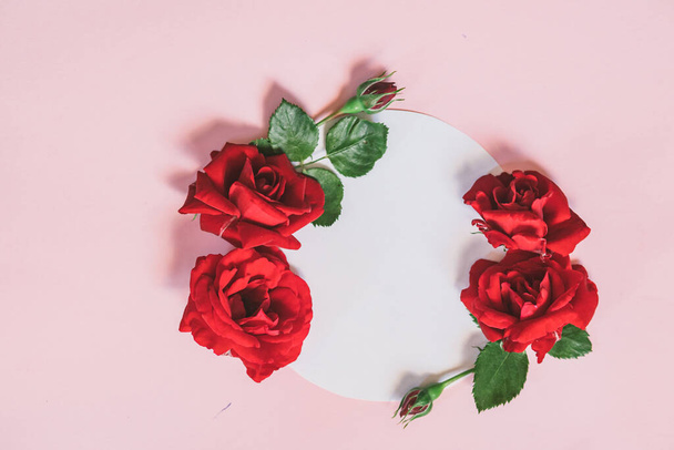 Floral wreath made of roses and leaves. Natural round frame isolated on pink. Holiday concept. - Foto, immagini