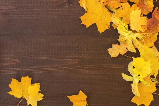 Dřevěný stůl s oranžovými podzimními listy, podzimní přírodní zázemí. Koncepce podzimních listů v podzimním období pozadí - Fotografie, Obrázek