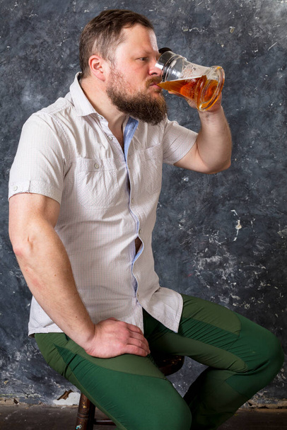 Matured smiling bearded man in shirt with beer mug - Fotoğraf, Görsel