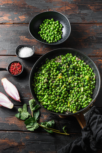 iceland mushy peas in frying pan and peas in bowl with mint shallot pepper and salt side view over old pub wood surface  vertical  ingredients. - Photo, Image