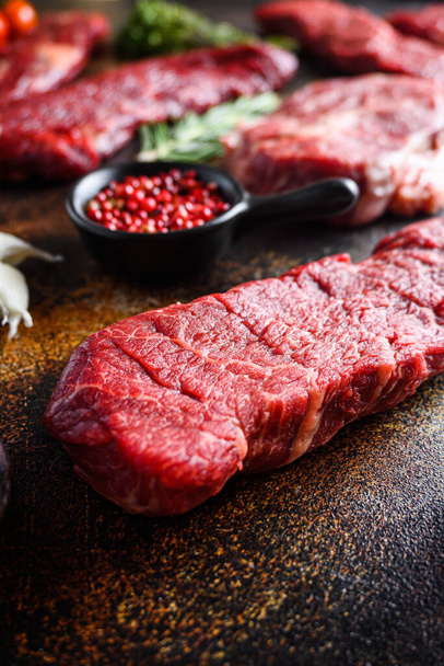 Side view Close up denver Steak, Flank steak, gesneden in de buurt van denver alternatieve rundvlees steak en een hakmes slager vlees mes een rustieke metall achtergrond verticaal. - Foto, afbeelding