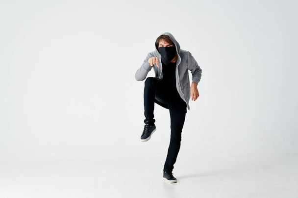 male thief in hood hidden mask tiptoe isolated fund - Fotó, kép