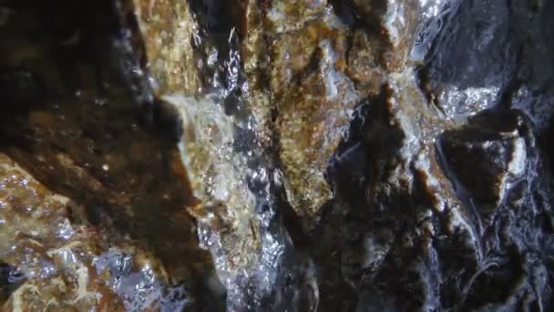 Kleine kreek van ijskoud water stroomt over de steen - Video
