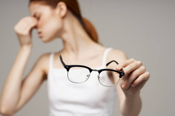 vrouw in wit t-shirt bril visie problemen bijziendheid - Foto, afbeelding