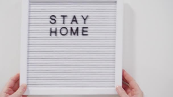 STAY HOME en COVID-19 sign on message board met een zelfgemaakt gezichtsmasker. - Video