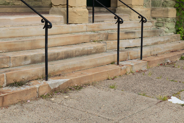 Crumbling limestone exterior steps of a church, black metal handrails, weathered and worn, horizontal aspect - Photo, Image
