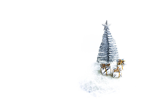 Εορταστική χιόνι φόντο με μικρό διακοσμητικό χριστουγεννιάτικο δέντρο και δώρα - Φωτογραφία, εικόνα