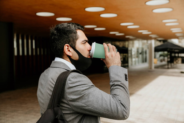 Successful young businessman walking and drinking coffee. Outdoor. - Foto, Bild