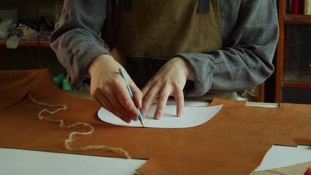 Mladý řemeslník přemýšlí o vytvoření nových kožených bot pro svůj podnik. - Fotografie, Obrázek
