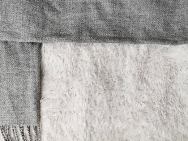 Woolen scarf of grey color on white background, top view, space for text. Winter clothes - Foto, afbeelding