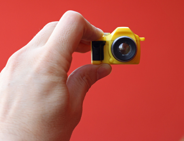 fotógrafo mientras está en un temporizador con una pequeña cámara de juguete
 - Foto, Imagen