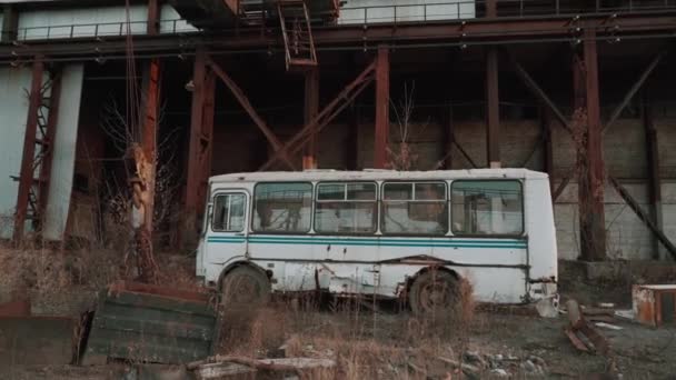 Opuszczony autobus w zardzewiałym krajobrazie przemysłowym z upiorną apokaliptyczną atmosferą - Materiał filmowy, wideo